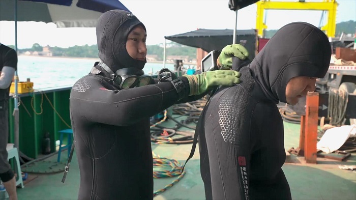 周强(左)与队友检查好装备,准备下水。(图片来源:山东省水下考古研究中心)